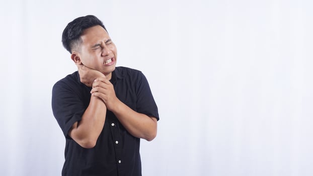 Asian Man Touching His Swollen Cheek Suffering from Toothache on White Background photo