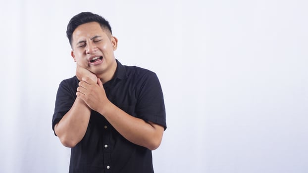 Asian Man with Swollen Cheek Suffering from Toothache on White Background photo