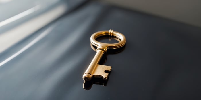 Shiny golden key on a sleek black surface. photo