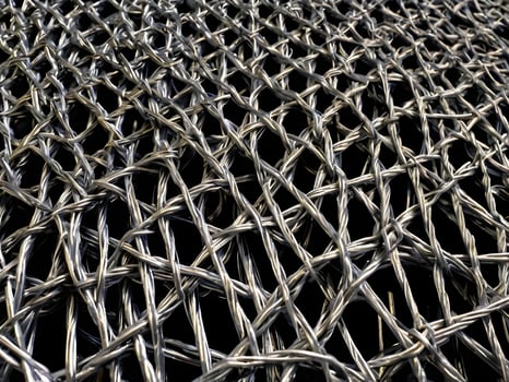 A finely focused shot of metal wire mesh, displaying a complex, repeating geometric design. photo
