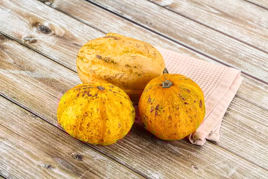 Three small pumpkins on a wooden table photo