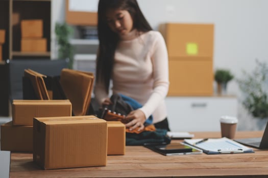 A woman is packing boxes in an office photo