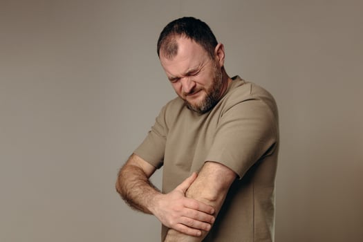 man experiences elbow pain due to joint problems, arthritis, bursitis or epicondylitis tennis elbow. diagnosis treatment, physical therapy or use of painkillers. diseases musculoskeletal system. photo