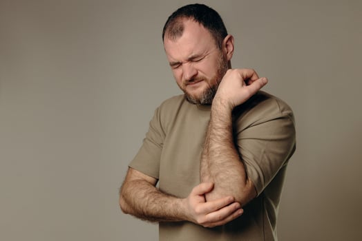 man experiences elbow pain due to joint problems, arthritis, bursitis or epicondylitis tennis elbow. diagnosis treatment, physical therapy or use of painkillers. diseases musculoskeletal system. photo