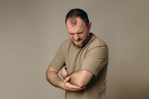 A man experiences problems in the elbow after intense physical exercise, long training or professional activities. performing a warm-up and recovery after physical exercise. photo