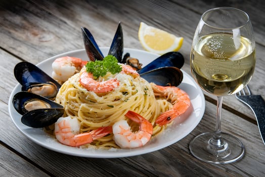 Delicious Seafood Pasta Dish with a Glass of White Wine photo