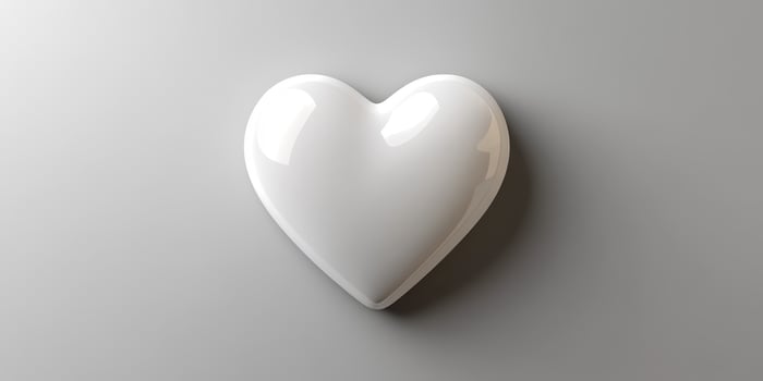 Decorative white heart sculpture on a smooth surface reflecting soft light indoors photo