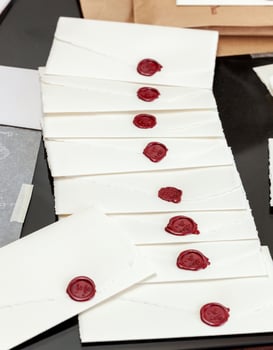 Elegant wedding invitations with red wax seals waiting to be sent photo