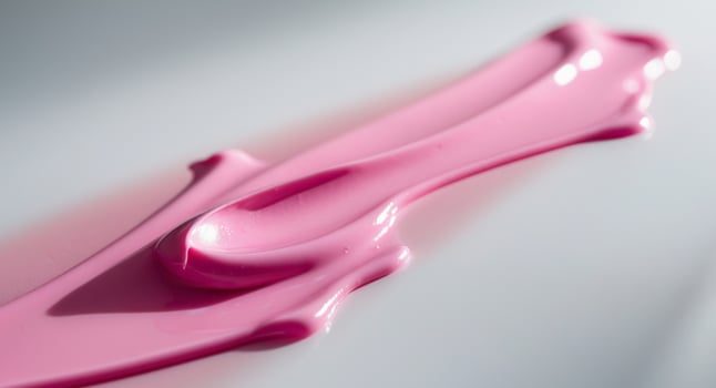 A pink liquid is being poured onto a surface photo