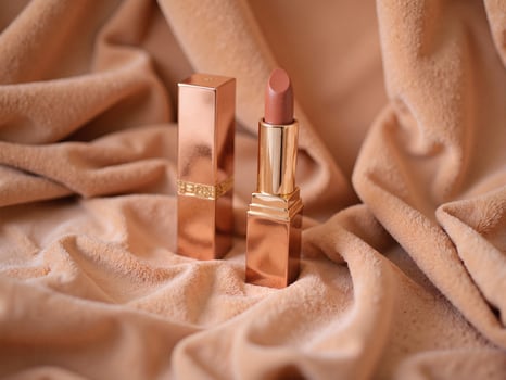 A lipstick sitting on a tan cloth photo
