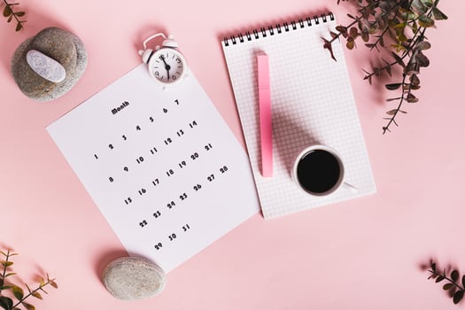 Monthly calendar and blank planning notebook on the desktop top view photo