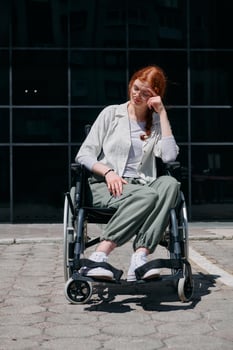 In front of a modern corporate building, a young woman sitting in a wheelchair confidently, symbolizing empowerment, inclusivity, and the strength to overcome challenges in the business world photo