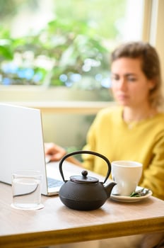 The freelance lifestyle a woman working remotely in a cafe, enjoying coffee as she types on her laptop. photo