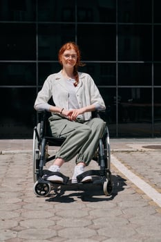 In front of a modern corporate building, a young woman sitting in a wheelchair confidently, symbolizing empowerment, inclusivity, and the strength to overcome challenges in the business world photo