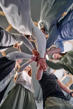 A group of young businessmen offer their hands together, symbolizing togetherness in the business world photo