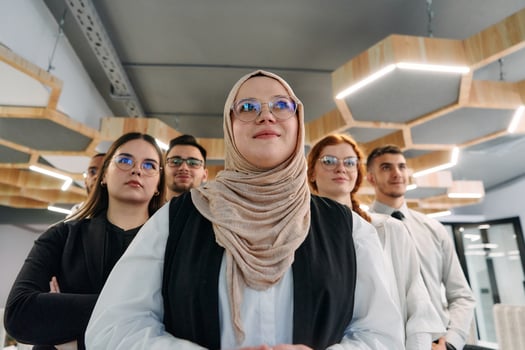 A group of business professionals standing together, taking a well-deserved break from their busy workday, showcasing camaraderie, teamwork, and a moment of relaxation in their dynamic workplace photo