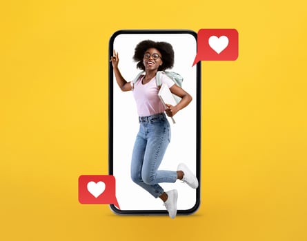 A joyful young woman with curly hair jumps from a large smartphone. She holds a backpack, showing enthusiasm for technology and connection through messaging and social media. photo