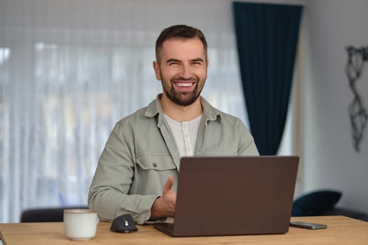 A happy man using a laptop while working at home office. photo