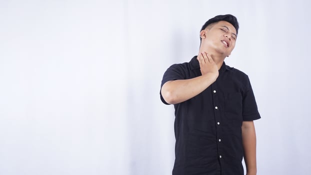 Asian Man Do Self Massage at His Neck Suffering from Neck Pain on White Background photo