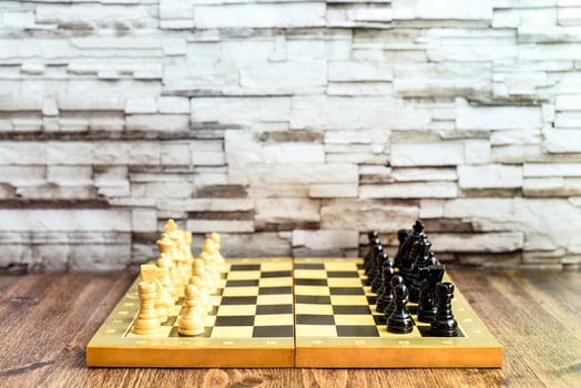Chess pieces on chess board on wooden table. Blurred background with copy space photo