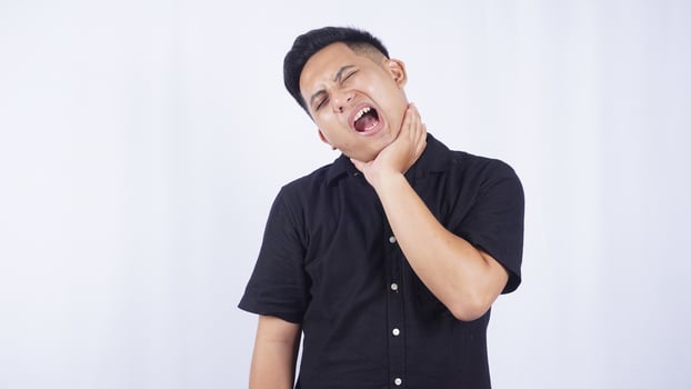 Sick Asian Man Feels Discomfort in His Throat on White Background photo