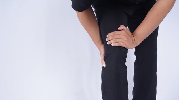 Man Suffering from Knee Pain on White Background photo