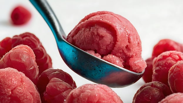 Extreme closeup of a raspberry sorbet scoop surrounded by fresh raspberries photo