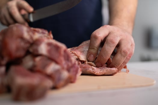 Talented Butcher Hands Skillfully Preparing Fresh Meat in a WellEquipped Kitchen Setting photo