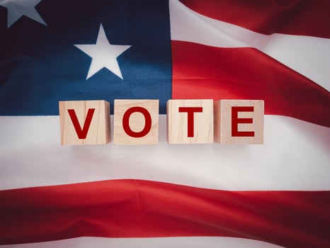 Wooden cubes with letters VOTE over the American flag background photo