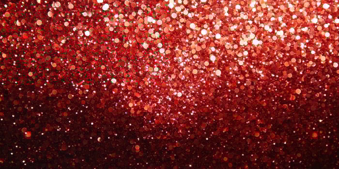 Bright red glitter sparkles creating a shimmering backdrop for celebrations and special events photo