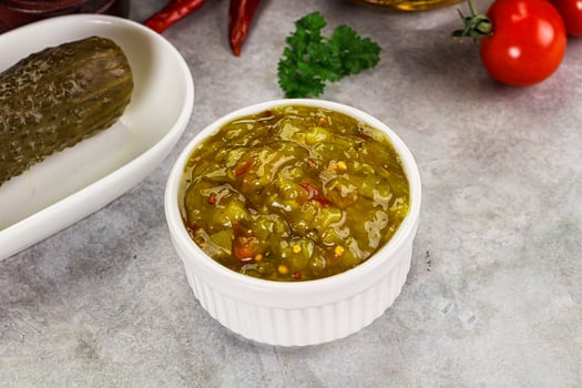 A bowl of pickles and a pickle on a table photo
