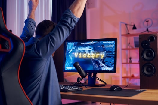 A man is sitting at a desk with his arms up photo