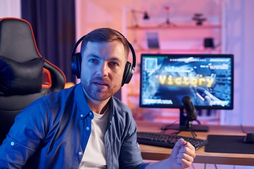 A man is sitting in front of a computer with headphones on photo