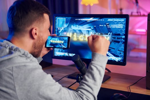 A man is playing a game on a computer monitor photo