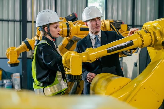 Engineer and technician examining robotic arms in a manufacturing facility photo