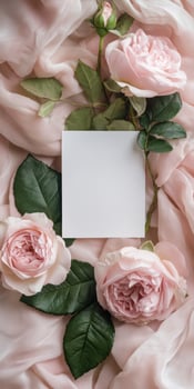 Elegant blank white greeting card amidst pink roses and silk fabric for romantic occasions photo