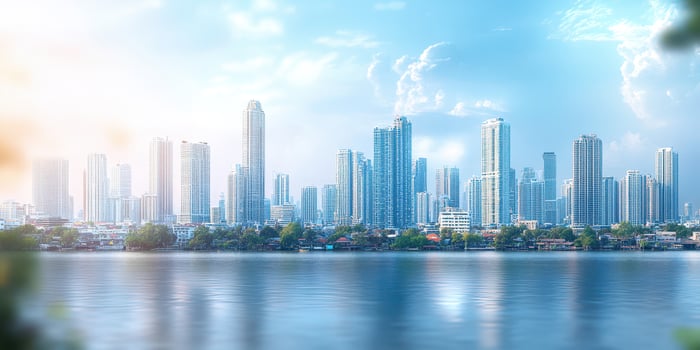 City skyline reflects in the water during a sunny day with scattered clouds and greenery in the foreground photo