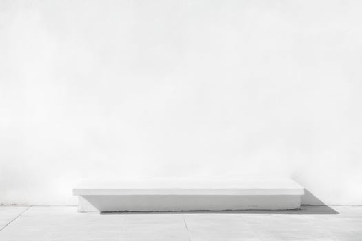 Minimalist white platform in front of textured white wall on a tiled floor, bathed in sunlight photo