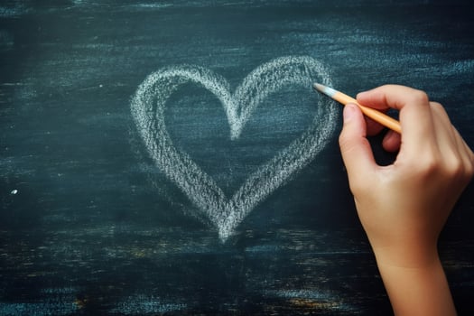 Hand drawing heart shape on chalkboard surface photo