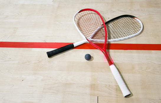 Squash Rackets And a Ball on a Wooden Court Floor. Sport Theme. photo