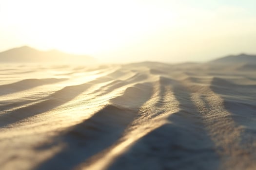Golden sunrise illuminating desert sand dunes photo