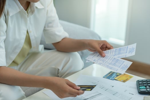 Stressed and headache asian woman with large bills or invoices no money to pay to expenses and credit card debt. shortage, Financial problems, mortgage, loan, bankruptcy, bankrupt, poor. photo