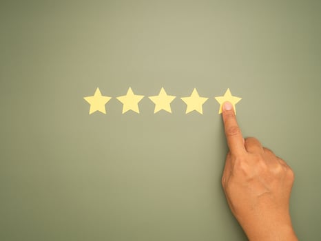 Rating for Satisfaction present by hand of client pressing Five Star photo