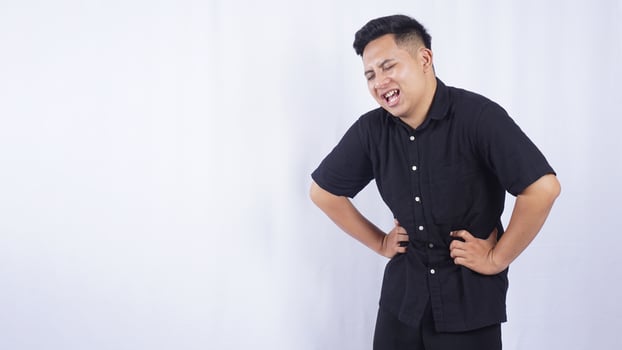 Sick Asian Man with Stomachache on White Background photo