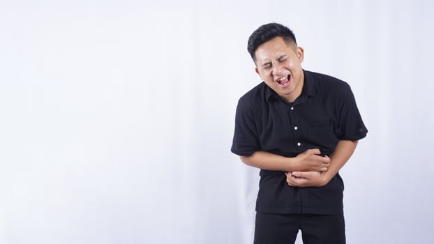 Sick Asian Man with Abdominal Pain on White Background photo