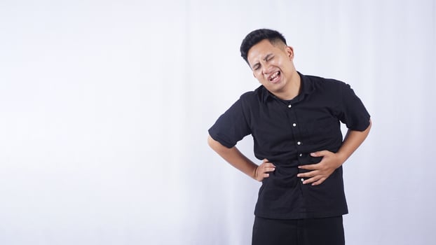 Portrait of Asian Man with Abdominal Pain on White Background photo