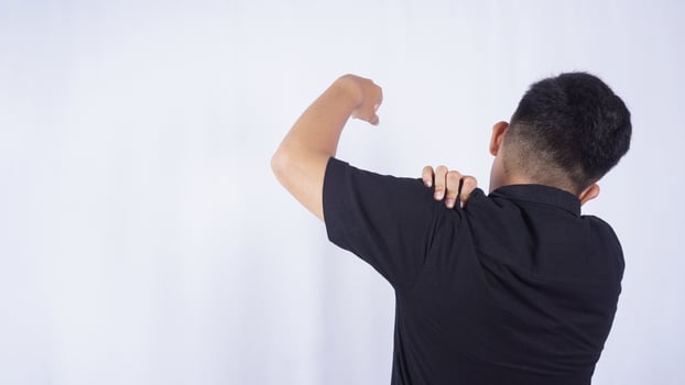 Rear View of Man Suffering from Stiff Muscle with Shoulder Pain on White Background photo