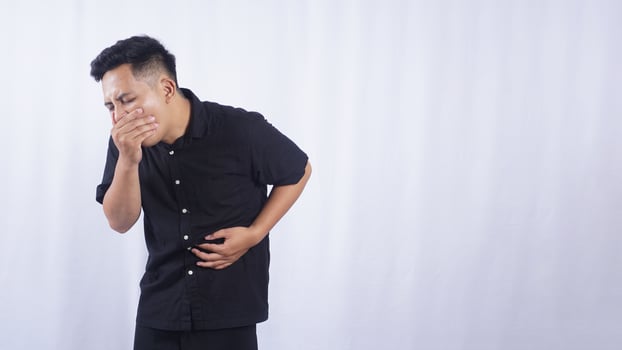 Unhappy Asian Man with Abdominal Pain on White Background photo