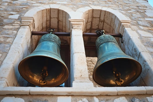 Two large bronze bells hanging in a stone bell tower are waiting to ring photo