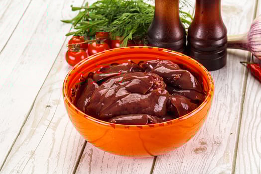 A bowl of meat and vegetables on a table photo